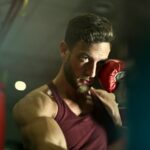 Bearded male boxer in gym focusing intensely during training session.